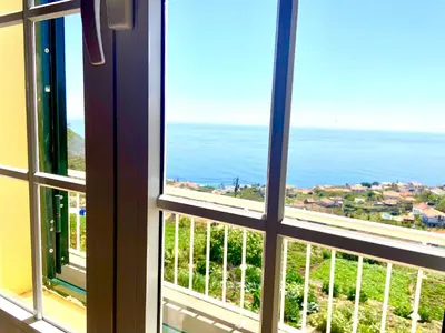 a dining room and kitchen with a table and chairs at Casa Neves three bedrooms and fantastic sea view in Arco da Calheta