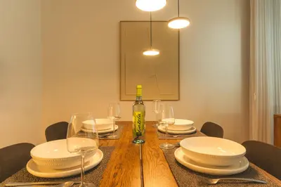 a dining room table with plates and a bottle of wine at Terrace Apartment by Atlantic Holiday in Funchal