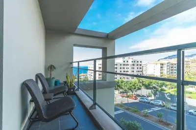 a balcony with two chairs and a view of a street at Terrace Apartment by Atlantic Holiday in Funchal