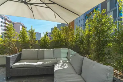 a couch sitting on a patio under an umbrella at Terrace Apartment by Atlantic Holiday in Funchal