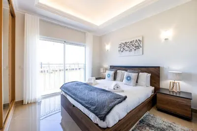 a bedroom with a large bed and a large window at Casa Malhotra at Boa Vista Golf Resort, Bayview Village in Lagos