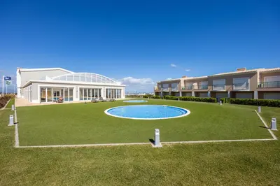 a large yard with a swimming pool in front of a building at Casa Malhotra at Boa Vista Golf Resort, Bayview Village in Lagos