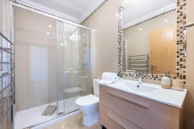 a bathroom with a toilet and a sink and a shower at Casa Malhotra at Boa Vista Golf Resort, Bayview Village in Lagos