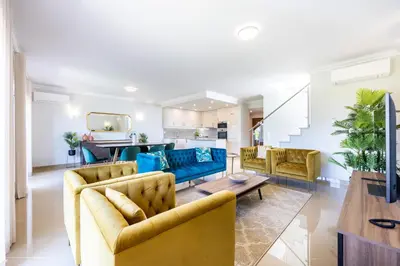 a living room with two couches and a table at Casa Malhotra at Boa Vista Golf Resort, Bayview Village in Lagos