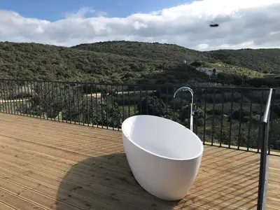 a bath tub sitting on top of a wooden deck at Nature&Soul - MAR in Vila do Bispo