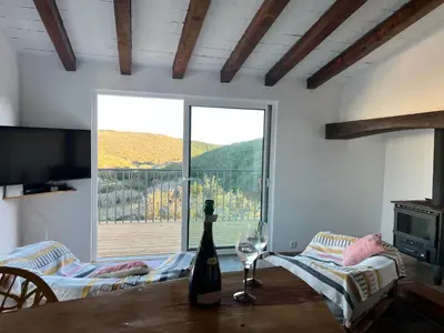 a bottle of wine sitting on a table with a window at Nature&Soul - MAR in Vila do Bispo