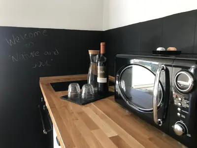 a toaster oven with wine bottles and glasses on a counter at Nature&Soul - MAR in Vila do Bispo