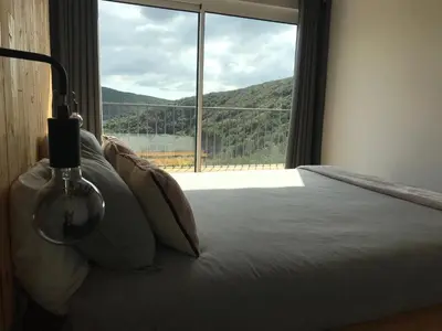 a bedroom with a bed with a large window at Nature&Soul - MAR in Vila do Bispo