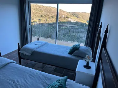 two beds in a room with a large window at Nature&Soul - MAR in Vila do Bispo