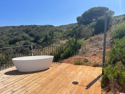 a bath tub sitting on a wooden deck at Nature&Soul - MAR in Vila do Bispo
