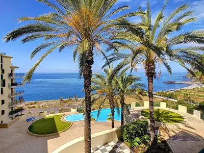a view of a resort with palm trees and the ocean at Vila Formosa Top View by LovelyStay in Funchal