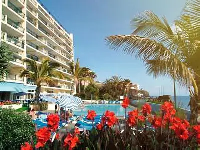 a pool with red flowers in front of a hotel at Lovely apartment with pool and sea view in Funchal