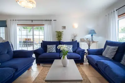 a living room with blue couches and a table at Villa Estrella - Praia da Luz in Luz