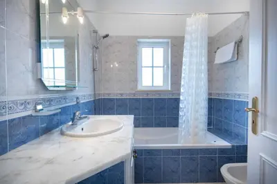a blue tiled bathroom with a sink and a tub at Villa Estrella - Praia da Luz in Luz