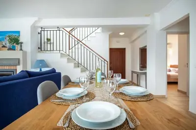 a dining room with a table with plates and wine glasses at Villa Estrella - Praia da Luz in Luz