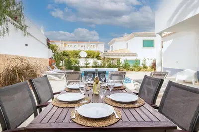 a wooden table and chairs on a patio at Villa Estrella - Praia da Luz in Luz