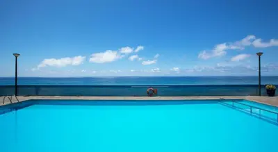 a swimming pool with the ocean in the background at Tranquil Beachside Stay - Atlantic Gardens Beach in Funchal