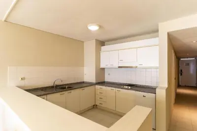 an empty kitchen with white cabinets and a sink at Tranquil Beachside Stay - Atlantic Gardens Beach in Funchal