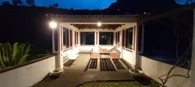 two chairs sitting on a porch at night at Paraíso Resiliente in Santana