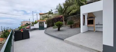 a balcony of a house with a gate and plants at Villa Castanho I in Calheta