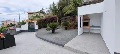 a courtyard of a house with a green door at Villa Castanho I in Calheta