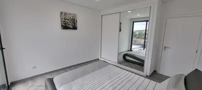 a white room with a mirror and a chair at Villa Castanho I in Calheta
