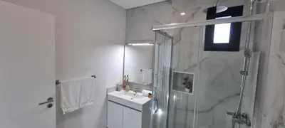 a white bathroom with a shower and a sink at Villa Castanho I in Calheta