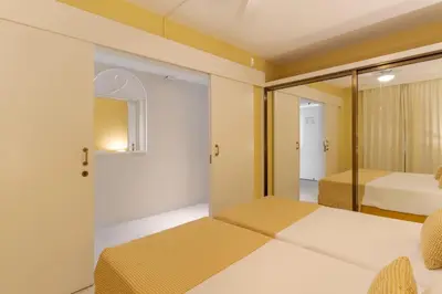 a bedroom with two beds and a mirror at Atlantic Gardens Beach - atlanticgardensbeach com in Funchal