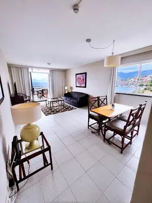 a living room with a table and chairs and a couch at Atlantic Gardens Beach - atlanticgardensbeach com in Funchal
