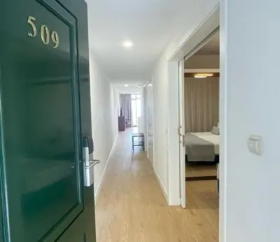 a hallway with a green door and a bedroom at Atlantic Gardens Beach - atlanticgardensbeach com in Funchal