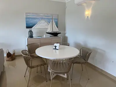 a dining room with a white table and chairs at Fairway 3 Apartment - Boavista Golf & Spa Resort in Lagos