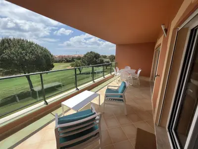a balcony with chairs and tables and a view at Fairway 3 Apartment - Boavista Golf & Spa Resort in Lagos