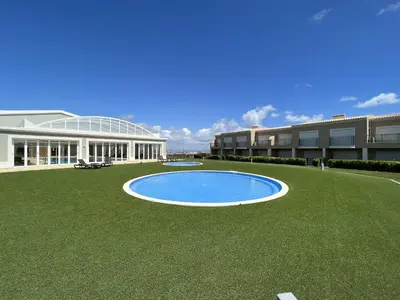a large building with a pool in the middle of a lawn at Fairway 3 Apartment - Boavista Golf & Spa Resort in Lagos