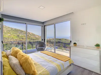 a bedroom with a bed and a large window at Wild River Villa by LovelyStay in Ribeira Brava