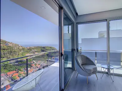 a balcony with a chair and a view of the ocean at Wild River Villa by LovelyStay in Ribeira Brava