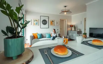 a woman sitting on a couch in a living room at MIO Apartment by Homie in Funchal