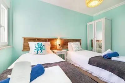 two beds in a room with blue walls at NEW beach flat with TOP VIEW - 3 min to sea in Luz in Luz