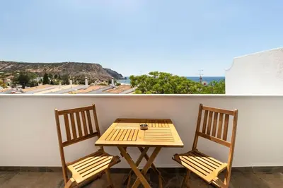 a table and two chairs on a balcony with a view at NEW beach flat with TOP VIEW - 3 min to sea in Luz in Luz