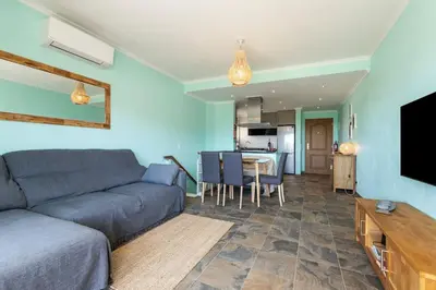 a living room with a couch and a table and a kitchen at NEW beach flat with TOP VIEW - 3 min to sea in Luz in Luz