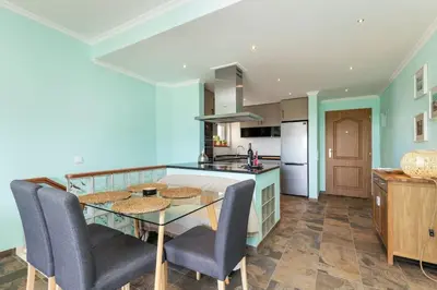 a kitchen with a glass table and blue walls at NEW beach flat with TOP VIEW - 3 min to sea in Luz in Luz