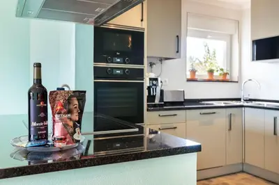 a bottle of wine sitting on a counter in a kitchen at NEW beach flat with TOP VIEW - 3 min to sea in Luz in Luz