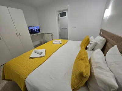a bedroom with a large bed with a yellow blanket on it at Sleep and Go in Santana in Nature B&B in Santana