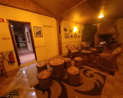 a living room with a bunch of stools and a fireplace at Sleep and Go in Santana in Nature B&B in Santana