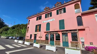 a pink building on the side of a street at Sleep and Go in Santana in Nature B&B in Santana