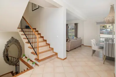 a living room with a staircase and a dining room at Strategic Sunset House by An Island Apart in Santa Cruz