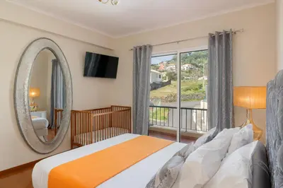 a bedroom with a bed and a mirror and a window at Strategic Sunset House by An Island Apart in Santa Cruz