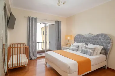 a bedroom with a large bed and a balcony at Strategic Sunset House by An Island Apart in Santa Cruz