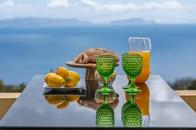 a table with two wine glasses and a plate of food at Strategic Sunset House by An Island Apart in Santa Cruz