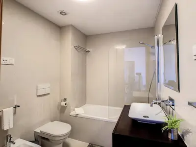 a bathroom with a toilet and a sink and a tub at Arigato Apartment by LovelyStay in Funchal