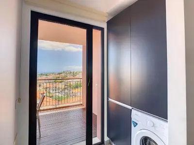 a laundry room with a door open to a balcony at Arigato Apartment by LovelyStay in Funchal